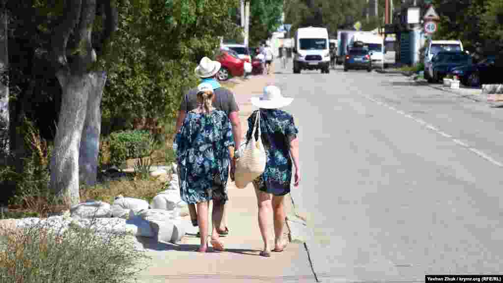 Відпочивальники йдуть з пляжу одною з головних вулиць у Любимівці – Южногородською