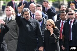 Presidenti venezuelas, Nicolas Maduro, ngre dy gishta ndërsa ai dhe gruaja e tij, Cilia Flores, largohen nga Sheshi i Kuq pas një parade ushtarake të Ditës së Fitores në Moskë, 9 maj 2025.