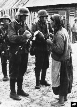 Україна. Друга світова війна. Фото агентства «Ассошіейтед прес», яке датоване 12 жовтням 1941 року, й котре підписане так: «Все, що ця українка могла запропонувати німецьким солдатам в Україні, – це глечик кислого молока, яке вони охоче прийняли»