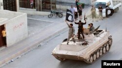 Militant Islamic State fighters take part in a military parade on the streets of the Syrian town of Raqqa, which was seized by the extremist group in August. (file photo)