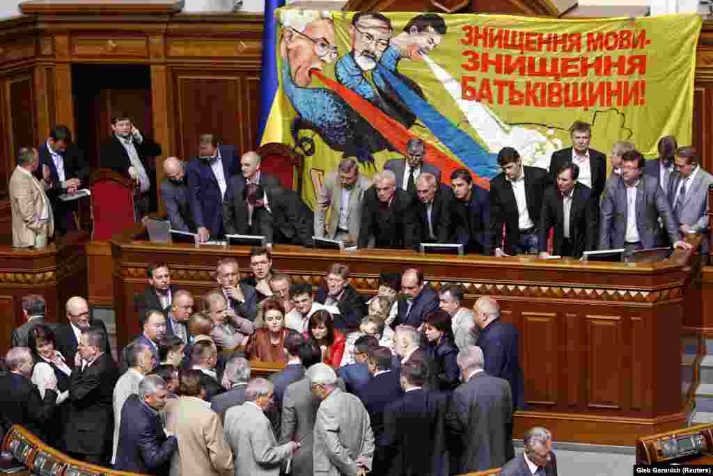 Опозиційні депутати блокують трибуну парламенту. На банері зображені (зліва направо): прем'єр Микола Азаров, міністр освіти Дмитро Табачник і президент Віктор Янукович. Київ, 25 травня 2012 року 