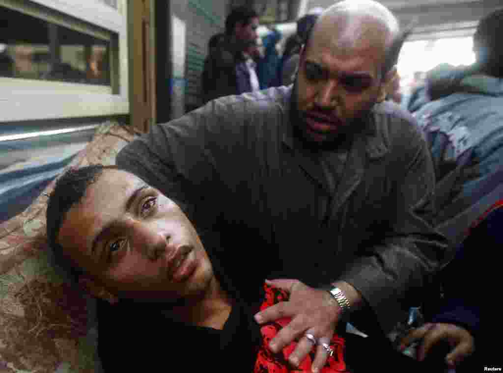A protester attends to an injured man during clashes in Cairo on January 28, 2011.