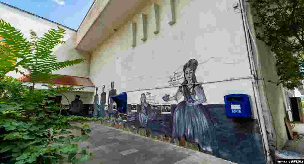 Граффити с изображением российских императоров на фасаде неработающего клуба бывшего санатория «Ливадия» на территории Ливадийского дворца-музея. Справа – императрица Екатерина II. Слева, у двери клуба, – Александр III