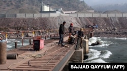 A Chinese engineer supervises workers building a bridge over a river in Ghari Dupatta, Pakistan.