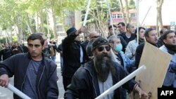 Opposition activists carry sticks and shields on the streets of Tbilisi
