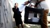 Azerbaijani election officials carry a mobile voting box for the presidential election in the village of Nardaran on October 9. 