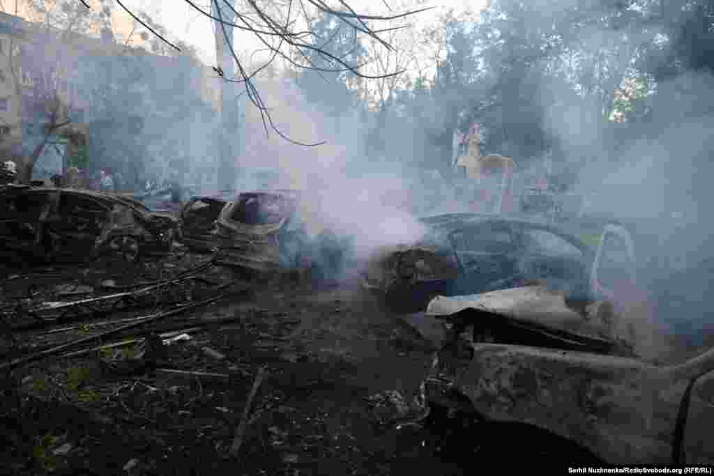 Обгорілі автомобілі у дворі будинку, в який влучила російська ракета