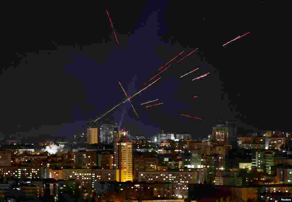 Трассеры и прожекторы видны в ночном небе, когда украинские военнослужащие ищут и стреляют по беспилотнику во время удара российского БПЛА, Киев, Украина, 3 ноября 2024 года. 