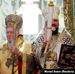 Вселенський патріарх Варфоломій (ліворуч) і глава Православної церкви України митрополит Епіфаній, який тримає томос про автокефалію. Стамбул, 6 січня 2019 року