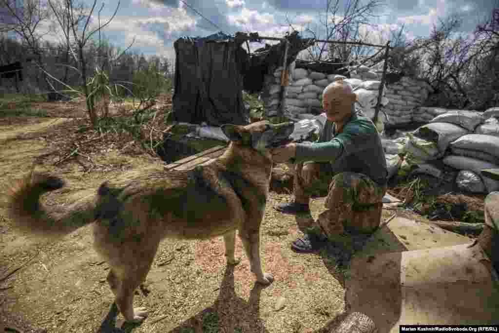 Uncle Misha, a Ukrainian soldier, rests before reporting for duty. It is common for the troops on the front lines to keep cats and dogs as pets.