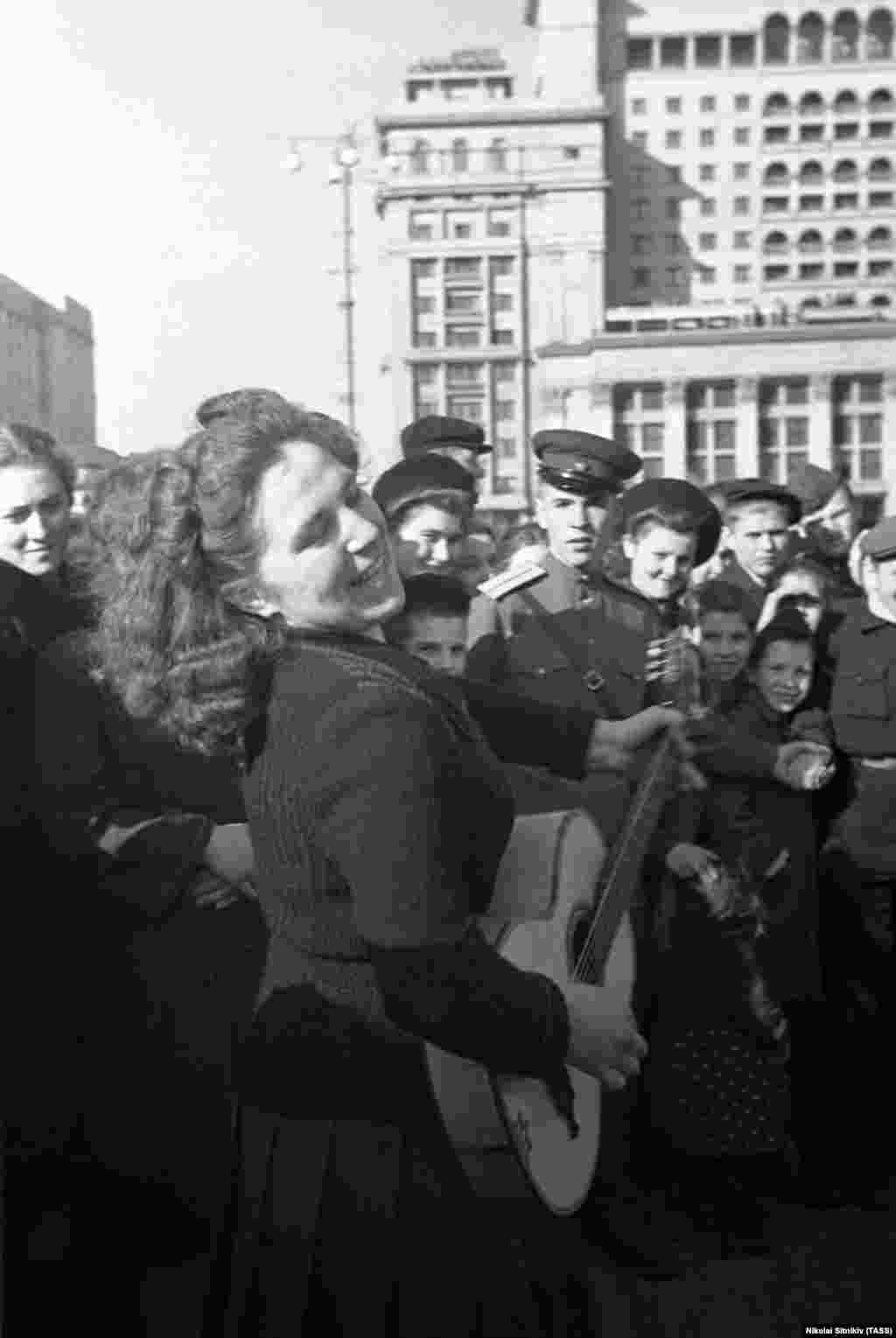 Moscova, URSS, 9 mai 1945 - O femeie cântă în centrul Moscovei. În Uniunea Sovietică, sărbătorile încep pe 9 mai.