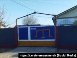 Оформление забора в синем и желтом цветах в частном доме села Урожайное Советского района во время полномасштабного вторжения РФ в Украину, апрель 2025 года