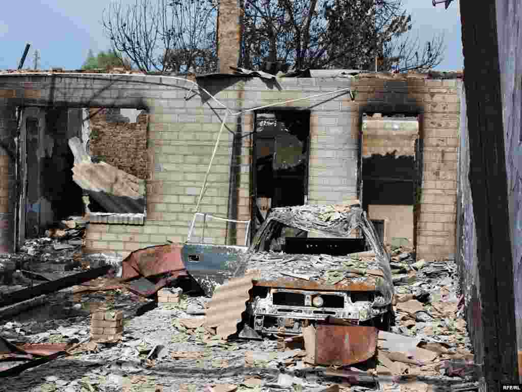 Burned-out buildings and a vehicle in the ethnic Uzbek Cheremushky neighborhood of Osh -