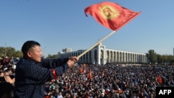 A protester in Bishkek waves the Kyrgyz flag at a rally earlier this week against disputed parliamentary election results.