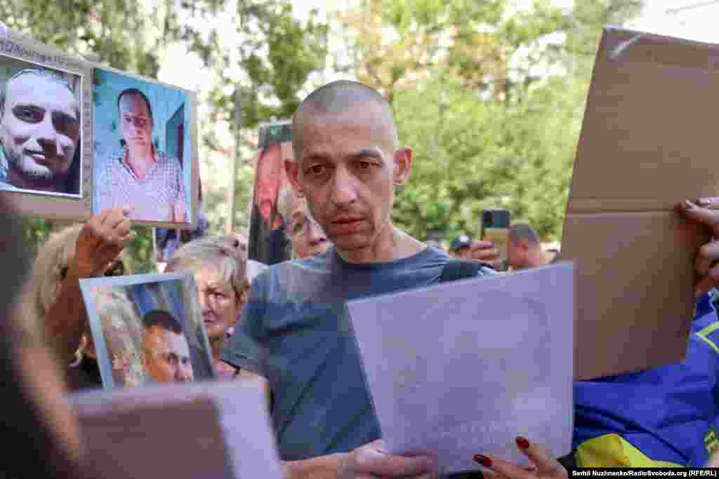 Звільнений із російського полону уважно розглядає фотографії полонених чи зниклих безвісти з надією упізнати когось.З російського полону сьогодні, як заявили в Координаційному штабі, повертаються дві пари рідних братів, які утримувалися в неволі з березня та квітня 2022 року