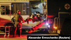 На ношах один із поранених українських бійців з «Азовсталі», яких привезли автобусом до Новоазовська, 16 травня 2022 року