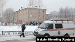 A vehicle from the Russian Emergencies Ministry stands parked near a local school in Perm after two assailants wearing masks injured schoolchildren and a teacher with knives on January 15.