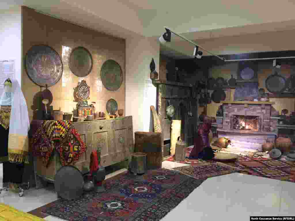 Именно так и выглядела изнутри горская сакля. На переднем плане – водоносные кувшины, деревянные мерки для зерна, сандук для хранения муки. В разноцветном приборе на сандуке держали ложки, вилки, ножи. В медные блюда (висят на стенах) клали еду для всей семьи. Слева на сандуке свисает хулжал (своеобразная сумка горцев), а поодаль – камин (по-аварски "гъасито")