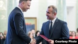 Оймаҳмад Раҳмонов, донишманди тоҷик (рост) ҳангоми гирифтани унвони профессорӣ аз тарафи Анджей Дуда, раиси ҷумҳури Лаҳистон. 7-уми марти 2018