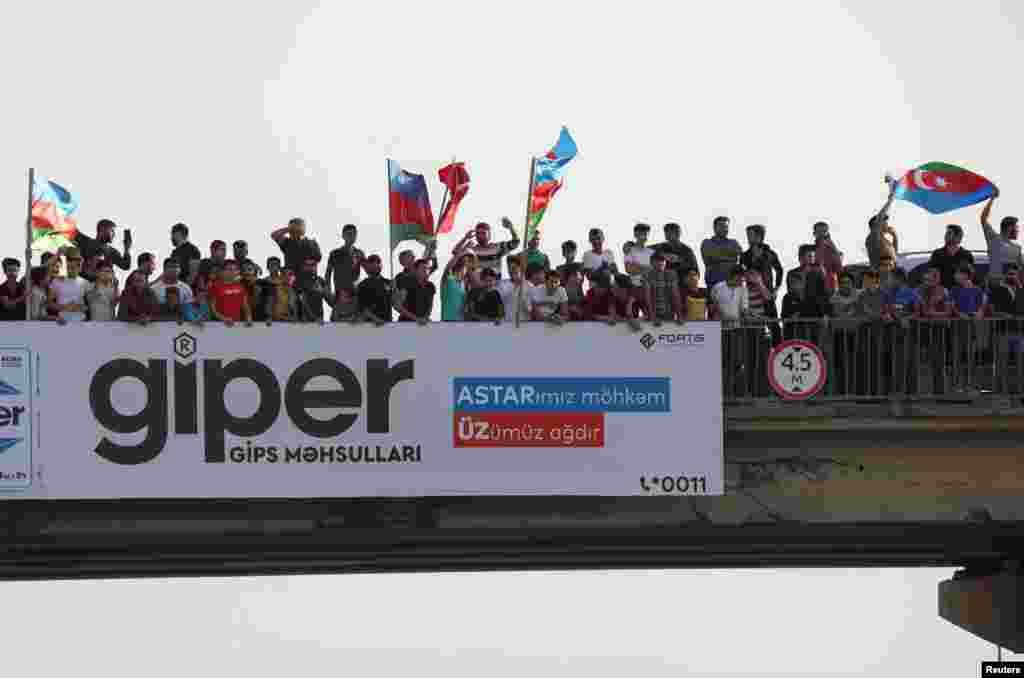 People gather on an overpass to cheer Azerbaijani soldiers in Baku shortly after the breakout of the current conflict in Nagorno-Karabakh on September 27. 