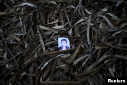A passport photo left behind by a migrant is seen among seaweed on a beach on the Greek island of Lesbos.