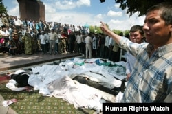 A man gestures to the bodies of victims killed in Andijon on May 14, 2005, the day after the violence.