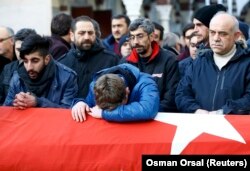Relatives mourn at the funeral of Ayhan Arik, a victim of the Istanbul nightclub attack.
