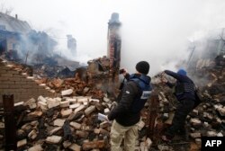 Члени спеціальної моніторингової місії ОБСЄ в Україні фотографують зруйнований будинок в Авдіївці після потужного обстрілу бойовиками гібридних сил РФ, 25 лютого 2017 року