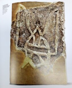 Знайдена в 1908 році в руїнах Десятинної церкви цегла з тризубом князя Володимира. Ілюстрація альбому «Наш герб: українські символи від княжих часів до сьогодення»