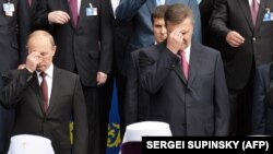 Президент Росії Володимир Путін (ліворуч) і тодішній президент України Віктор Янукович (праворуч) хрестяться під час богослужіння, приуроченого до 1025-річчя Хрещення України-Русі. Київ, 27 липня 2013 року