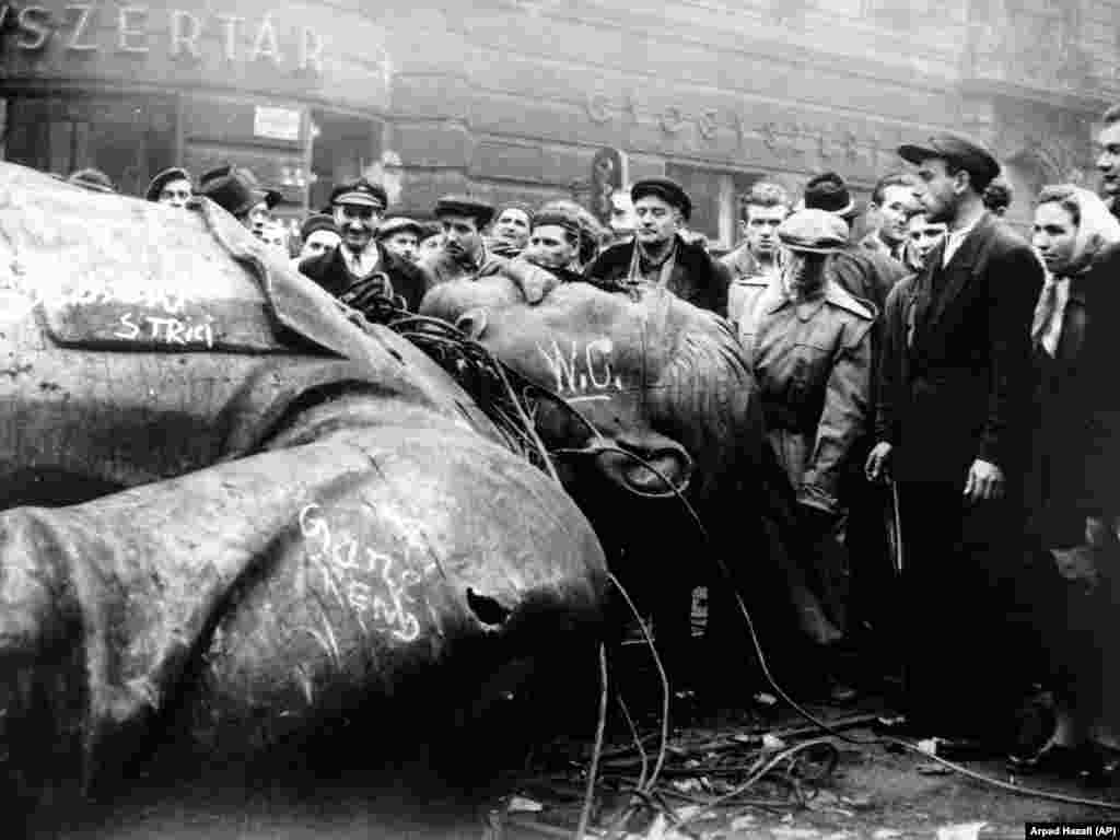 Ungurii înconjoară o statuie răsturnată a lui Iosif Stalin în timpul revoluției din 1956.În 1956, RFE a fost criticată pentru emisiunile pe care mulți le-au perceput ca încurajând revolta anti-comunistă din Ungaria. Revoluția a fost zdrobită de armata sovietică, ucigând mii de oameni. Într-o retrospectivă a emisiunilor RFE din 1956 către Ungaria, care includeau unele sfaturi tehnice privind menținerea impulsului revoluționar, un fost director al RFE a concluzionat că „nu este niciodată funcția [radioului] să le spună oamenilor ce ar trebui să facă – și cu atât mai puțin în condiții de revoltă violentă”.