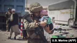 Службовиця 24-го експедиційного підрозділу морської піхоти США несе дитину під час евакуації в аеропорту Кабула. Афганістан, 28 серпня 2021 року
