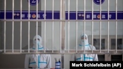 Китайские охранники в защитных костюмах в "Коррекционном центре №3" для задержанных уйгуров в городе Урумчи, столице Синьцзян-Уйгурского автономного района КНР. Апрель 2021 года