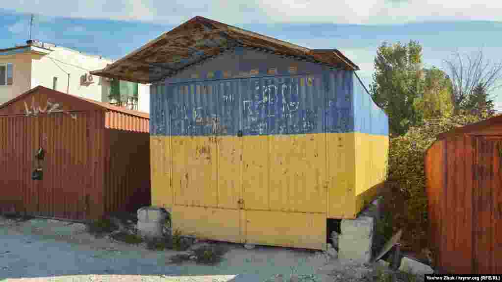 Колись у самому центрі села була і така торгова точка: до 2014 року цей синьо-жовтий гараж стояв на імпровізованому «центральному майдані». Після анексії Криму він став «заважати» російській владі Криму – господар був змушений його прибрати вглиб місцевого гаражного кооперативу, однак перефарбовувати не став