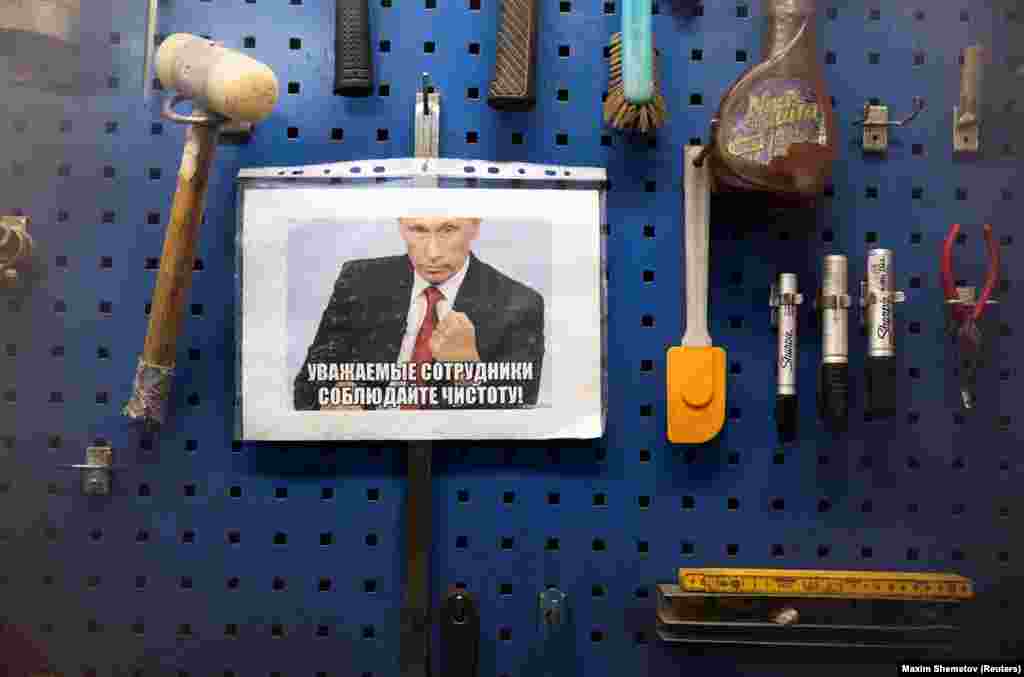A sign featuring Vladimir Putin saying “Dear colleagues, keep clean,” in a factory near Murmansk.  