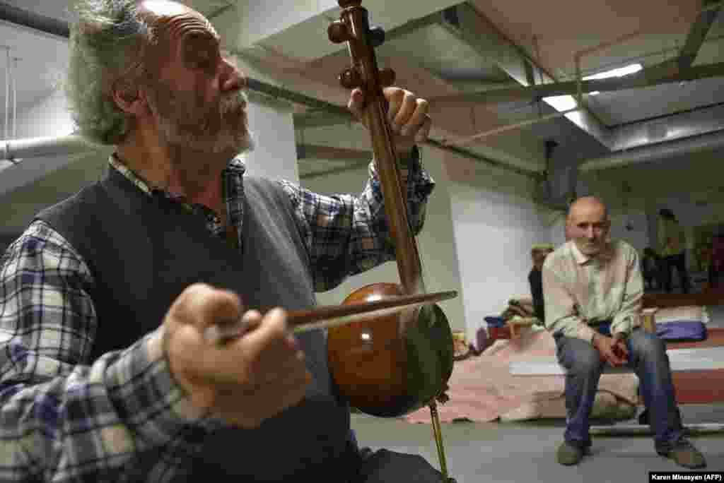 Armenian musician Hakob Khalatian plays his kamancha string instrument in a bomb shelter in Stepanakert on November 5. 