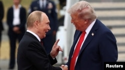 Путін тисне руку Трампу, пройшовши від трапа літака по червоній доріжці. Летовище у Анкоріджі. Аляска, США. 15 серпня 2025 року