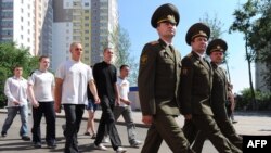 New Belarusian army recruits march behind officers near a recruiting station in Minsk