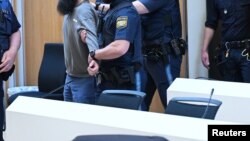 Alleged ringleader Dieter S. is escorted through the courtroom