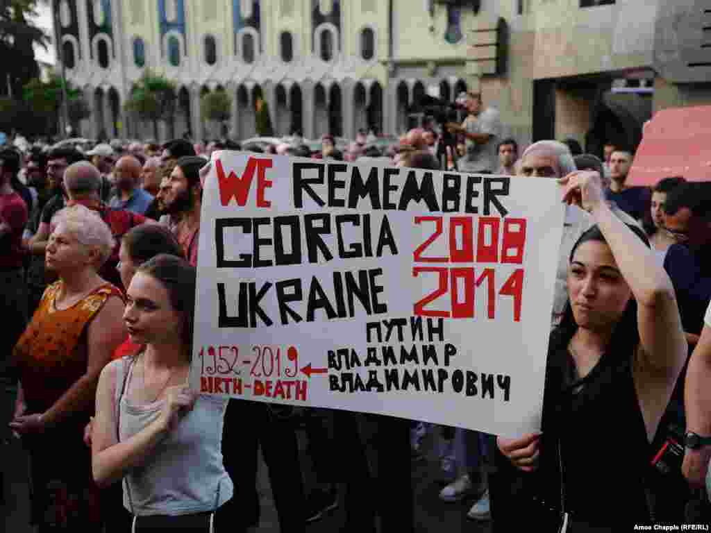 Activists' signs are referring to Georgia's 2008 conflict with Russian forces over the breakaway regions of South Ossetia and Abkhazia, when Russian tanks drove near Tbilisi, as well as the ongoing conflict in eastern Ukraine. Among the protesters' demands is the resignation of the country's interior minister, Giorgi Gakharia.