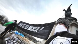 Protesters hold pictures and a banner asking "Who's next?" during a rally in Vienna on January 22 in memory of murder victim Israilov.