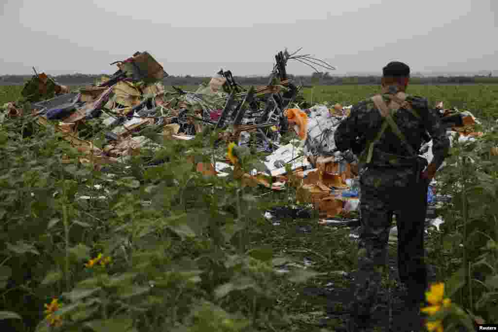Another pro-Russian separatist looks at wreckage from the nose section of the airliner near the village of Rozsypne on July 18. 