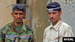 A member of the Sons Of Iraq (right) mans a checkpoint with a policeman in Samarra.