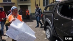 People crowd outside the Committee Against Torture's headquarters following an attack on the premises in Grozny on June 3.
