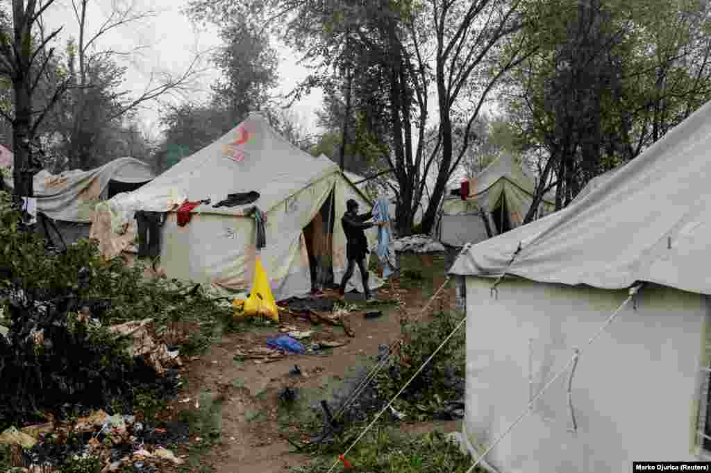 A migrant cleans his bedding among tents at the Vucjak camp. Since 2018, the EU has paid Bosnia 34 million euros ($37.4 million) to help manage the country’s migrant situation.  