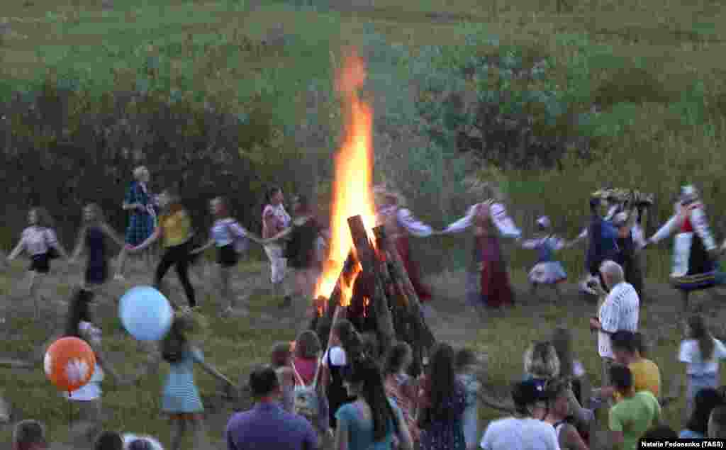 Люди танцюють навколо багаття