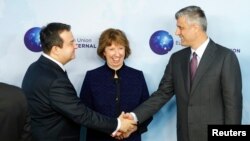 Serbian Prime Minister Ivica Dacic (left) shakes hands with Kosovo's Prime Minister Hashim Thaci during a joint meeting with European Union foreign-policy chief Catherine Ashton in Brussels on December 13.