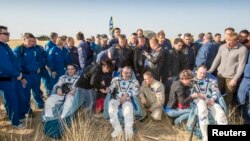 NASA astronaut Chris Cassidy (left), and Russian cosmonauts Commander Pavel Vinogradov (center) and Flight Engineer Aleksander Misurkin sit in chairs outside the Soyuz TMA-08M capsule just minutes after they landed Kazakhstan on September 11.
