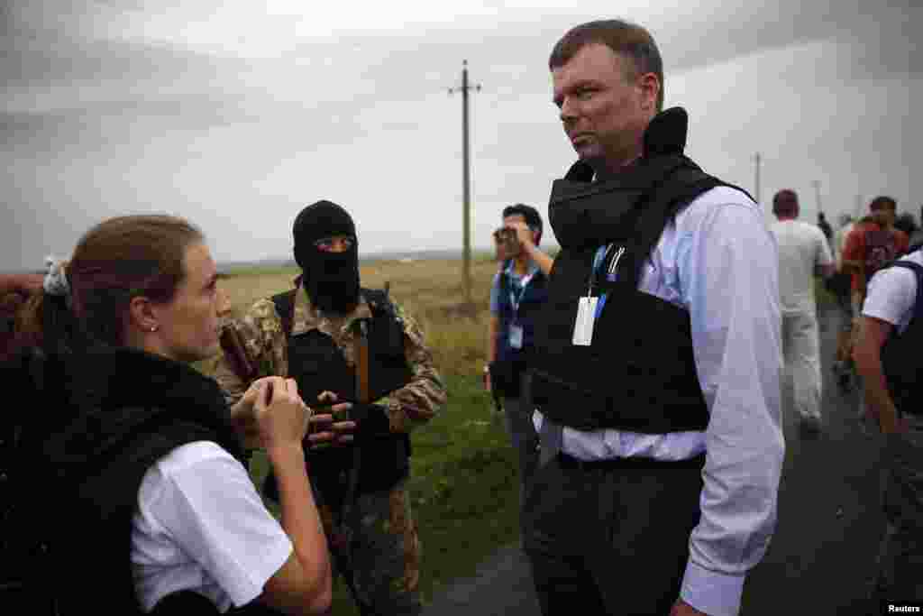 OSCE monitors speak with a pro-Russian separatist about gaining access to a crash site near Hrabove on July 18. 