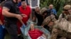 Police officers and medics evacuate Olha Trush, 86, from the village of Yarova, which was hit by a Russian aerial strike in Slovyansk, Donetsk region, on September 9.